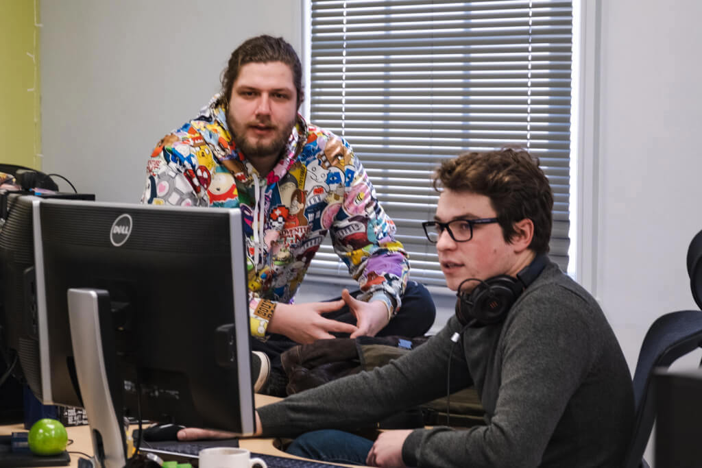 Photo of two Stainless Games team members working together at a computer